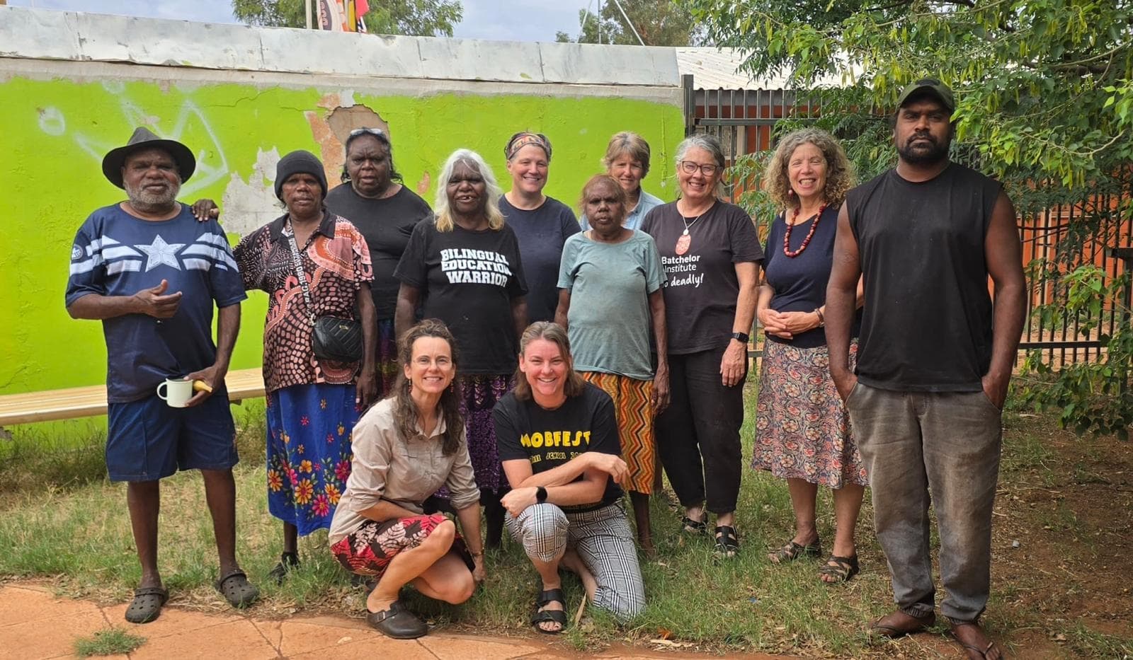 A group of community members and collaborators standing together outdoors.
