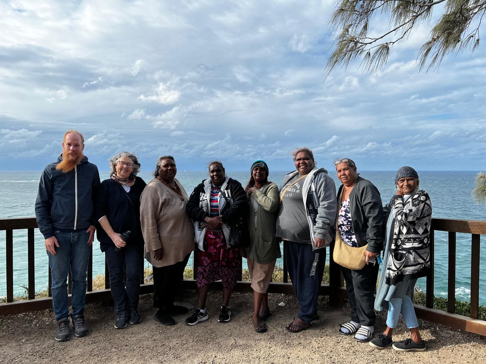 A group of collaborators standing together overlooking the coastline.